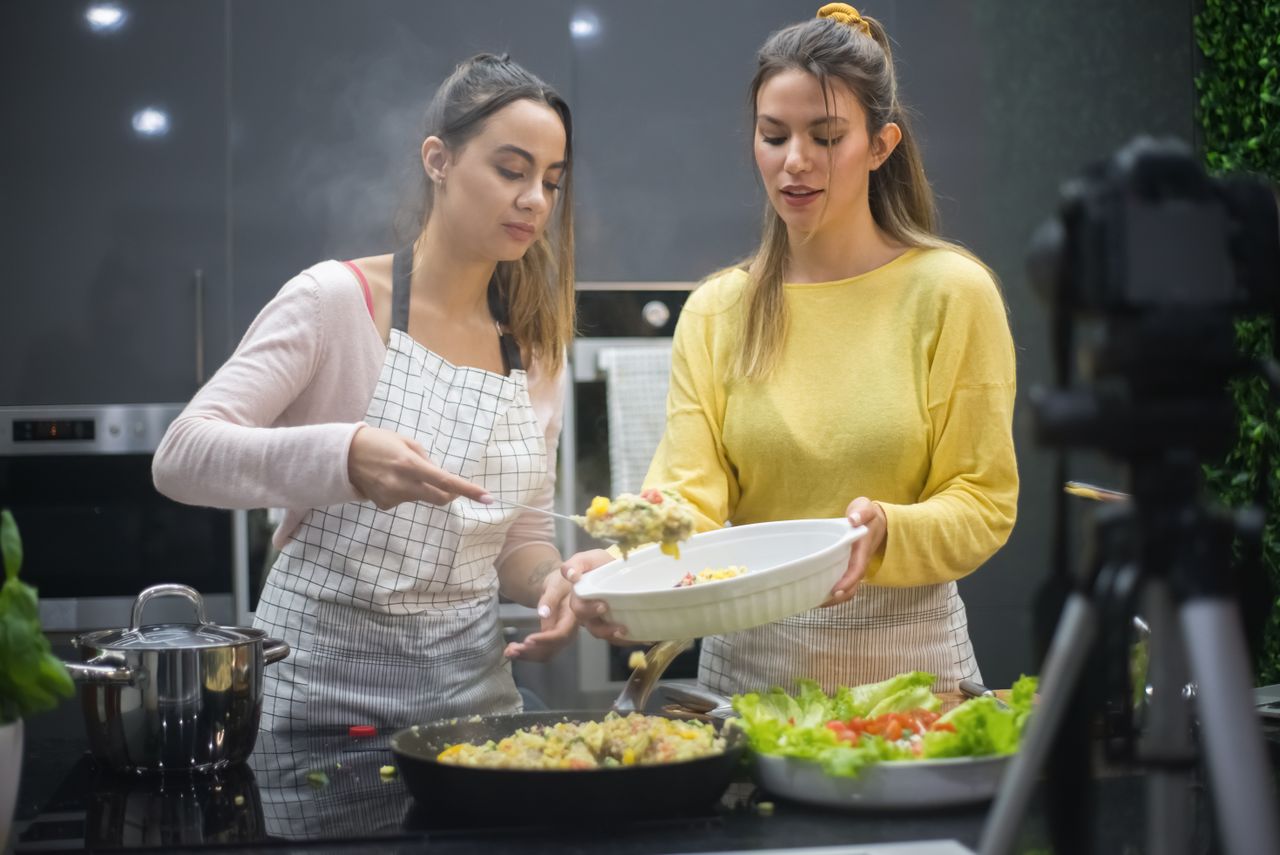 Two women prepare a delicious meal in a stylish kitchen, showcasing food preparation and culinary skills.