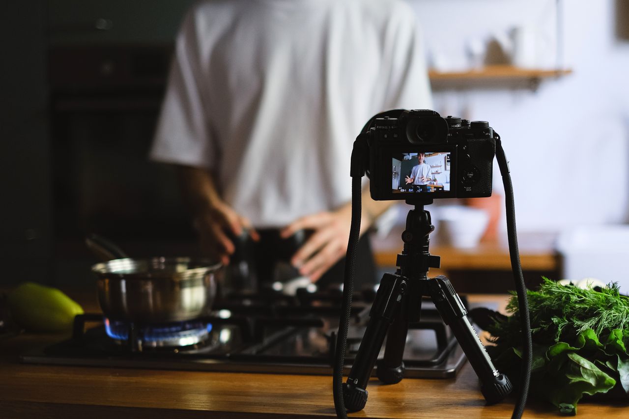 Une caméra enregistre un tutoriel de cuisine dans une cuisine moderne, avec des ingrédients frais.